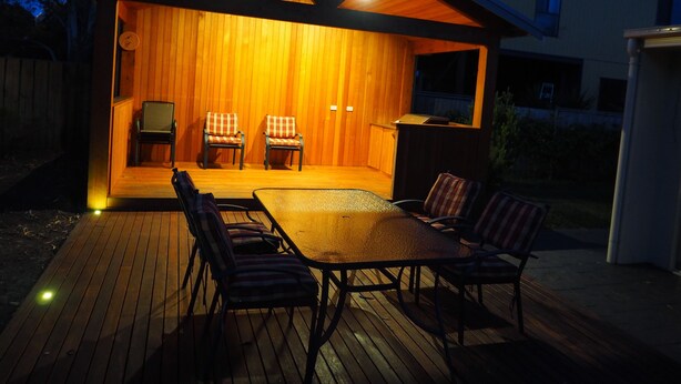 An outdoor wooden deck with a table and chairs, a barbecue grill, and a covered seating area with two chairs. - The Beachcomber , Linen Supplied, 10 minute Walk to Surf Beach (Inverloch)