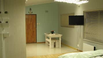 1 habitación, escritorio y tabla de planchar con plancha