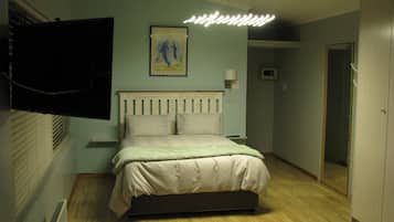 1 habitación, escritorio y tabla de planchar con plancha