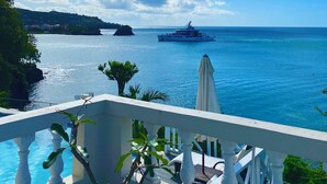 Ein Balkon mit Blick auf das Meer und eine Yacht.