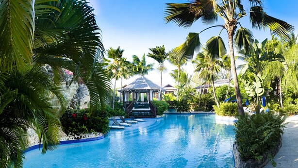A clear view of a swimming pool surrounded by palm trees and a gazebo. - Stunning, private villa on Barbados' Platinum west coast. (Gibbs)