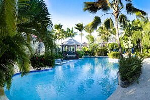 A clear view of a swimming pool surrounded by palm trees and a gazebo. - Stunning, private villa on Barbados' Platinum west coast. (Gibbs)