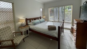 A bedroom with a bed, a nightstand, a chair, a TV, and a ceiling fan. - "Oxley House" - Scarborough Q 4020 (Scarborough)
