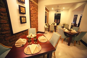 Enjoy meals in this cozy dining area with a brick accent wall, a dining table for four, and comfortable seating.