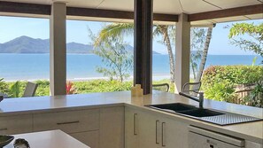 A kitchen with a view of the ocean and mountains.