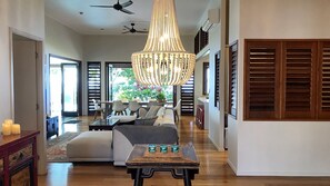 A spacious living area with a chandelier, a sofa set, and a coffee table.