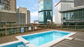 A rooftop pool with a wooden deck, surrounded by modern buildings. - Sydney- CLD01 Bridge Street - Modern 1BR with Rooftop Pool in the Heart of Sydney CBD (Sydney)