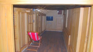 A wooden interior with a red chair and a television mounted on the wall. - Nature Castle-A traditional kerala style  (Vattavada)