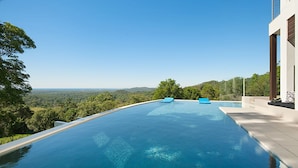 Ein moderner Infinity-Pool mit freiem Blick auf die umliegende Landschaft.