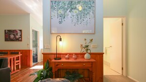 Un salon chaleureux avec un banc en bois, une table et une lampe fixée au mur.