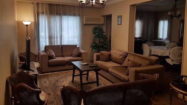 A living room with a sofa set, a coffee table, a floor lamp, and a dining area with a table and chairs. - in the center of Cairo (Cairo)