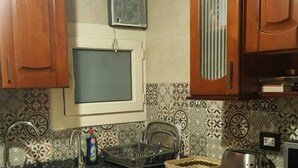 A kitchen with wooden cabinets, a built-in microwave, and a window above the sink. - in the center of Cairo (Cairo)
