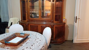 A dining area with a wooden cabinet containing glassware and a wicker tray on a lace tablecloth. - in the center of Cairo (Cairo)