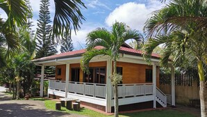 Ein zweistöckiges Haus mit rotem Dach, weißem Anstrich und einer Veranda.