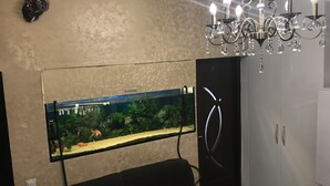 Ein Zimmer mit einem großen Aquarium, einer Chandelier und einem Kleiderschrank.