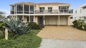 Een tweelaags huis met een balkon, een garage en een verzorgd gazon.