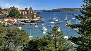 Un port de plaisance où de nombreux bateaux sont amarrés, entouré d’immeubles et d’arbres.