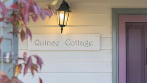Un rètol que diu "Quince Cottage" al mur, amb un fanal a dalt.