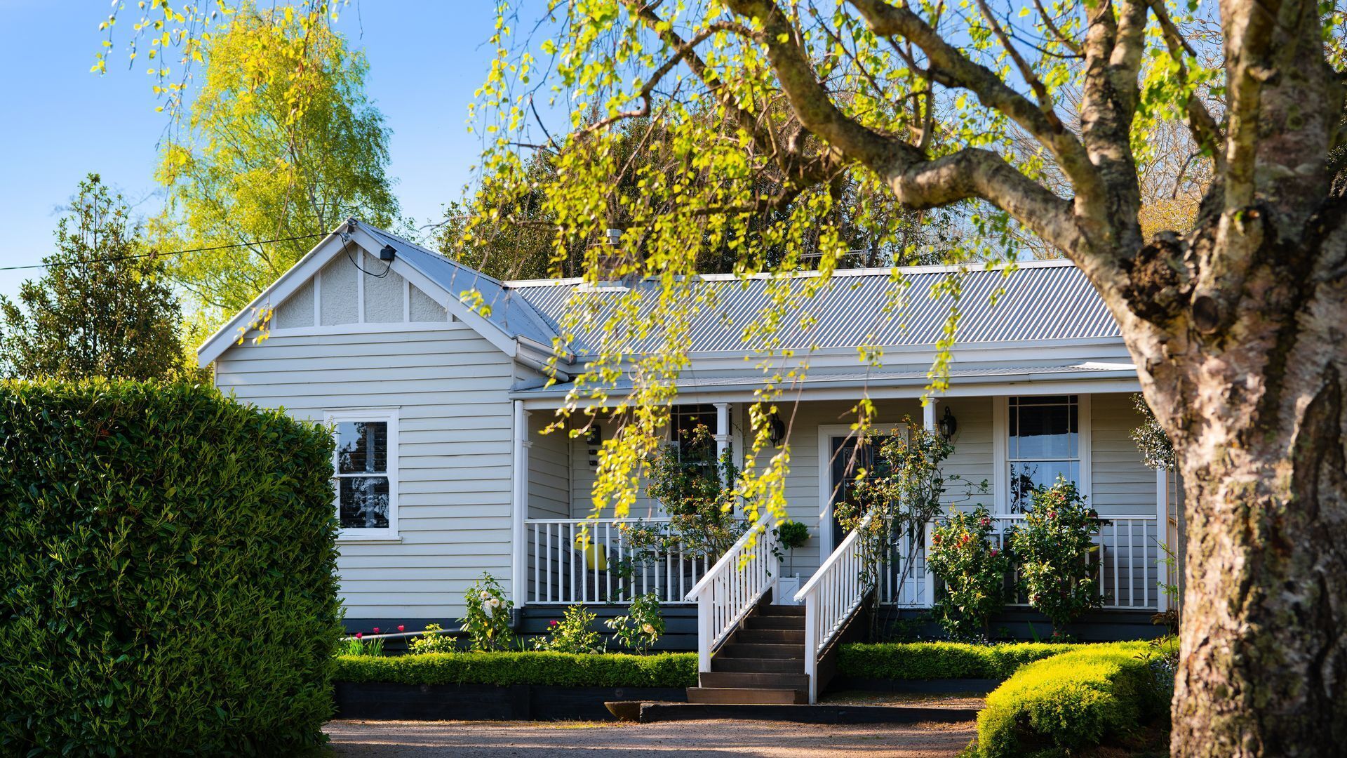 A two-story house with a front porch, a staircase, and a well-maintained garden.