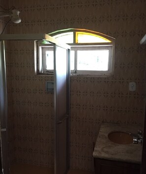 A bathroom with patterned wallpaper, a window above the sink, and a light fixture. - Nature and Welfare (Sete Barras)