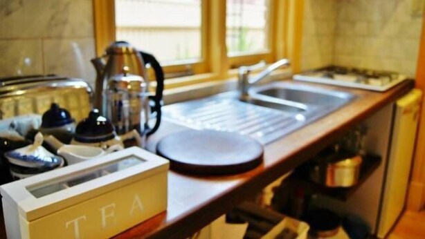 A kitchen with a tea station, a kettle, and a sink. - Cafe Spa Suite 1 bedroom (North Adelaide)
