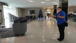 A modern lobby with a Christmas tree, seating area, and a large 'B' logo on the wall.