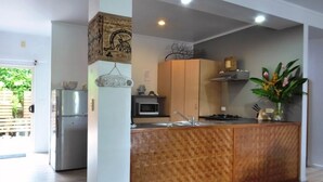 Una cocina moderna con una isla de madera, electrodomésticos de acero inoxidable y vistas al exterior.