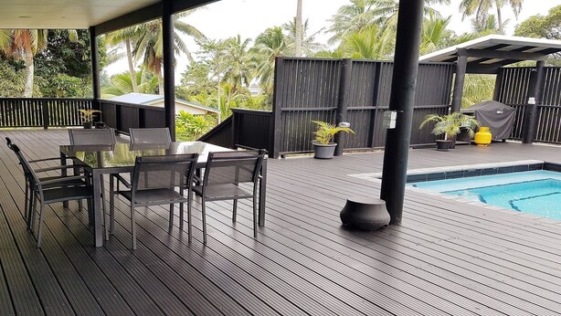 A wooden deck with a pool, outdoor seating, and tropical vegetation. - Boaza Place is situated in Nikao and offers an outdoor swimming pool.  (Puapuautu Tapere)