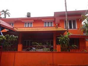 Residential building with a flat roof and windows with white frames, featuring a water tank and a staircase.
