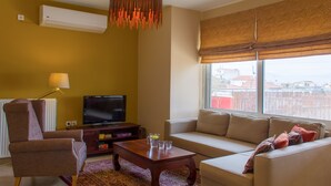 Uma sala de estar com sofá, poltrona, mesa de centro e televisão.