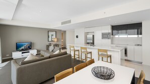 A modern apartment with a living room, dining area, kitchen, and a large window. - Apartment 22502. Located high on the 25th floor of this famous resort hotel (Surfers Paradise)