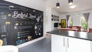 A modern kitchen with a blackboard wall displaying contact information and amenities. - Modern Bohemian Apartment with Pool, Fibre Wi-Fi and Bbq Patio in Centurion (Centurion)