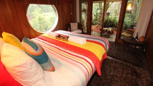 A bedroom with a large bed, a window, and a view of the outdoors.