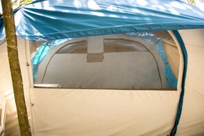 Experience a comfortable camping stay with a spacious tent featuring a clear entrance and a flat sleeping area.