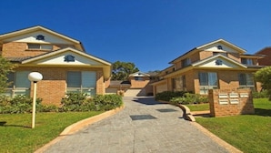 A residential area with two brick houses, each with a garage, a paved driveway, and a well-maintained lawn.