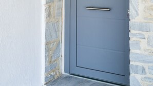 A grey door with a metal handle, a stone wall, and a sign that reads "Thetis". - Villa Thetis with private pool and sea view (Paros)