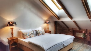 Ein Schlafzimmer mit einem großen Bett, zwei Nachttischen, einem Oberlicht und einer Ziegelwand.
