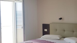 Un dormitorio con una cama, una silla y un escritorio.