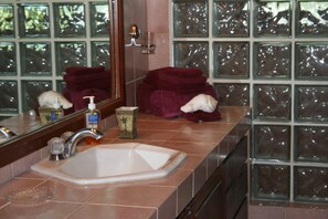 Ein Badezimmer mit großem Spiegel, Waschbecken und einer Duschkabine aus Glas.