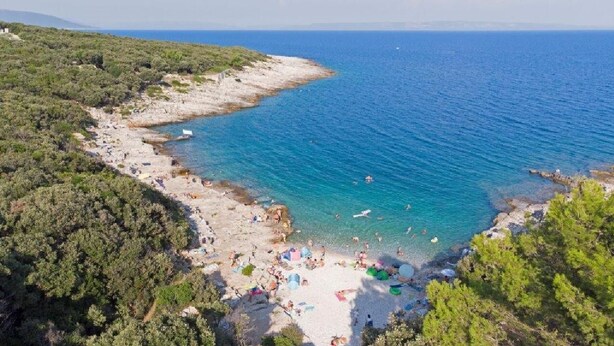 A coastal beach with clear blue waters, sandy shores, and lush greenery. - Holiday apartment in village Dobrani (Dobrani)