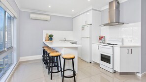 Enjoy cooking in this well-lit kitchen with a large island and stainless steel appliances.