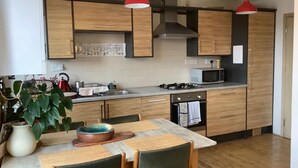 Eine moderne Küche mit Holzausstattung, einem Gasherd und einer Mikrowelle.