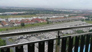 Un immeuble de grande hauteur offrant une vue sur un parking et les immeubles résidentiels environnants.