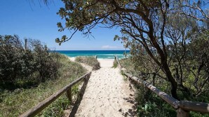 A sandy path leading to a beach with a clear view of the ocean. - White Sands Beach House (Marcoola)
