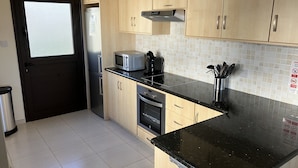 A modern kitchen with light wood cabinets, a black countertop, stainless steel appliances, and a tiled backsplash. - Private Pool - All En-Suite - Games Room - Large Sun Terrace - Full A/C - WiFi (Pissouri)