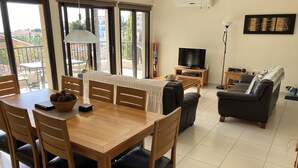 A spacious living area with a dining table, chairs, a sofa, and a TV. - Private Pool - All En-Suite - Games Room - Large Sun Terrace - Full A/C - WiFi (Pissouri)