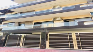 A multi-story building with balconies, air conditioning units, and a gated entrance. - Moksha- Salvation (Gurugram)