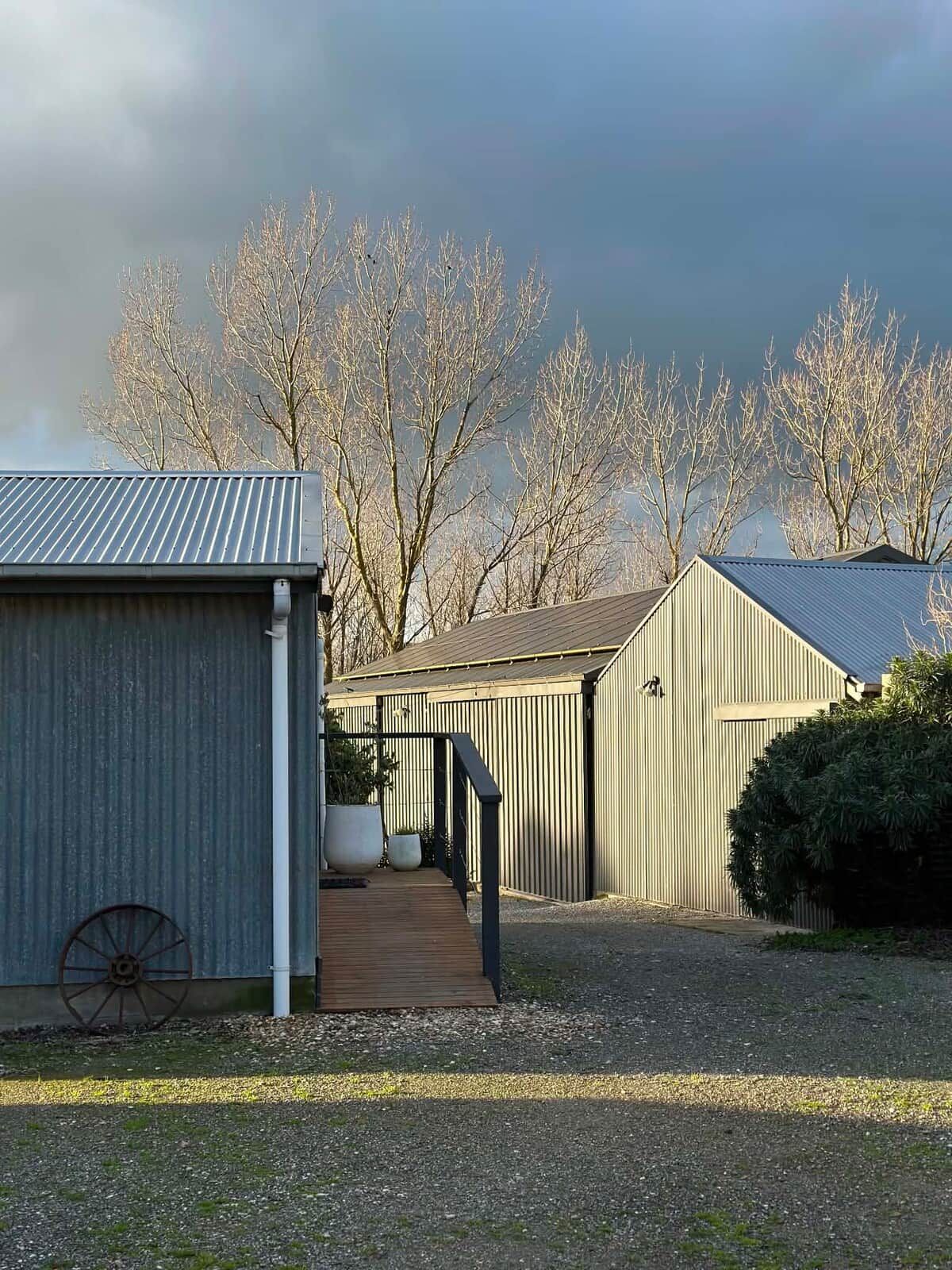 A building with a metal roof and a wooden deck leading to a covered area.