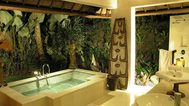 Ein Badezimmer mit einer großen Badewanne, einem Waschbecken und einer Duschkabine.
