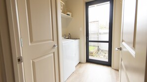 A narrow hallway leading to a door with a view of a backyard.